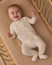 Load image into Gallery viewer, Smiling baby lying in a wooden crib wearing a cream Hanukkah-print zip footie with enclosed feet.