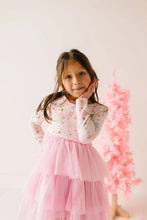 Load image into Gallery viewer, Close-up of a child in the Sugar Plum dress, showing the pastel holiday-print bodice and layered pink tulle skirt.