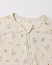 Load image into Gallery viewer, Close-up of the cream footie’s neckline and zipper guard with muted gold menorah, dreidel, and Star of David motifs.