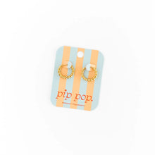 Load image into Gallery viewer, Gold-tone braided hoop earrings displayed on a pastel blue and peach striped Pip Pop card.