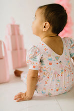 Load image into Gallery viewer, Close-up of the Sugar Plum romper’s V-shaped back neckline, puff sleeves, and gathered waist on a seated baby.