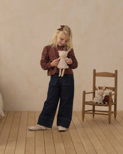 Load image into Gallery viewer, Child holding Bonnie the Bear beside a wooden chair with other animal dolls.