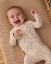Load image into Gallery viewer, Laughing baby with one arm raised, wearing a cream footie patterned with menorahs, dreidels, and stars.