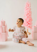 Load image into Gallery viewer, Baby looking upward in a pastel holiday-print Sugar Plum romper, showing the puff sleeves and ruffled ankle cuffs.