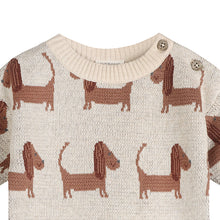 Load image into Gallery viewer, Close-up of a cream knit sweater with a repeating brown dachshund pattern and two metal buttons at the collar.