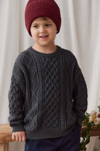Load image into Gallery viewer, A young child wearing a dark gray cable-knit sweater and a burgundy knit beanie, standing indoors against a soft cream curtain backdrop.