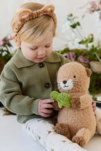 Load image into Gallery viewer, Child holding Ollie the Otter plush on their lap and touching its little green turtle companion.