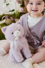 Load image into Gallery viewer, Close-up of violet Moon the Kitty plush beside a smiling child, showing its dark eyes, pink nose, and cream bow.