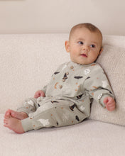 Load image into Gallery viewer, A baby wearing a light gray long-sleeve footed sleeper with a Halloween print of bats, ghosts, and moons, sitting on a textured cream blanket.