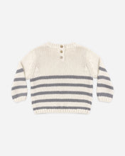 Load image into Gallery viewer, A cream-colored knit baby sweater with horizontal gray stripes across the body and sleeves, featuring a three-button henley neckline, shown on a light gray background.