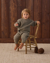 Load image into Gallery viewer, Child sitting on a wooden chair wearing spruce green chunky knit pants with ribbed cuffs and a matching sweater.
