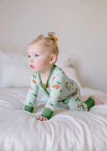 Load image into Gallery viewer, Baby in a colorful onesie sitting on a white surface