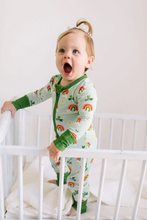 Load image into Gallery viewer, Child in a crib wearing a green pajama with rainbow patterns