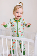 Load image into Gallery viewer, Baby in a colorful onesie standing in a crib