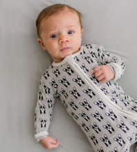 Load image into Gallery viewer, Baby wearing a onesie with black and white patterns on a gray background