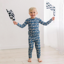 Load image into Gallery viewer, Child wearing blue pajamas with car pattern, holding checkered flags against a white background
