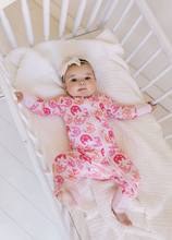 Load image into Gallery viewer, Baby in a crib wearing a pink and orange outfit with a white crib in the background