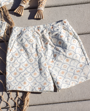 Load image into Gallery viewer, Floral patterned shorts on a textured surface