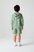 Load image into Gallery viewer, Child wearing a green hoodie and shorts set on a plain background