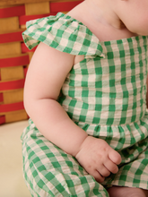 Load image into Gallery viewer, Child wearing a green and white checkered dress with a colorful background
