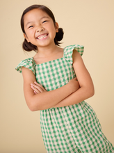 Load image into Gallery viewer, Young girl wearing a green checkered outfit against a beige background
