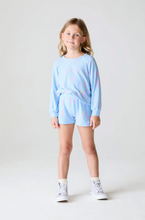 Load image into Gallery viewer, Young girl wearing a light blue outfit with colorful accents on a white background