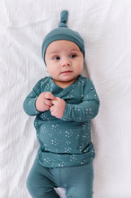 Load image into Gallery viewer, Baby wearing a teal outfit with star pattern on a white background