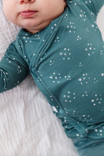 Load image into Gallery viewer, Baby wearing a teal onesie with white star patterns on a white blanket