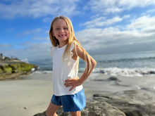 Load image into Gallery viewer, Young girl standing on a beach with ocean and sky in the background
