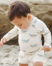 Load image into Gallery viewer, Child wearing a crocodile-patterned outfit on a beach