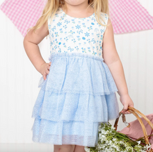 Load image into Gallery viewer, Child wearing a white dress with blue floral patterns and a matching blue ruffled skirt, holding a basket.