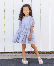Load image into Gallery viewer, Young girl wearing a light blue dress standing against a white wooden fence.