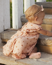 Load image into Gallery viewer, Child in a pink dress sitting on wooden steps outdoors