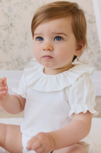 Load image into Gallery viewer, Baby wearing a white outfit with ruffled sleeves sitting on a soft surface.