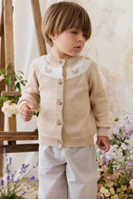 Load image into Gallery viewer, Child wearing a beige cardigan in a floral setting