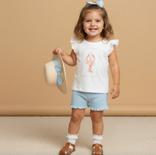 Load image into Gallery viewer, Young girl in a white top with a lobster design and light blue shorts, holding a straw hat with a blue ribbon, against a beige background.