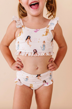 Load image into Gallery viewer, Child wearing a mermaid-themed two-piece swimsuit on a beige background