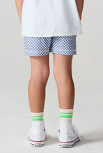 Load image into Gallery viewer, Person wearing blue checkered shorts and white sneakers with green accents on a plain background