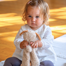 Load image into Gallery viewer, Child holding a plush toy in a softly lit room