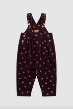 Load image into Gallery viewer, A pair of toddler girl's overalls in deep purple featuring gold-tone metal buttons and straps, shown against a light gray background.
