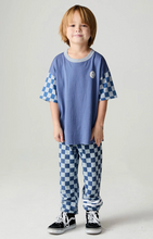 Load image into Gallery viewer, A young boy stands against a light gray studio background wearing a blue short-sleeve t-shirt with blue-and-white checkered sleeves, matching checkered pants, and black low-top sneakers.