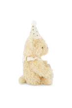 Load image into Gallery viewer, Side view of Party Arthur teddy bear seated on a white background, showing its cream neck ribbon and small rounded tail.
