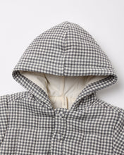 Load image into Gallery viewer, Close-up of a hooded quilted jacket in a gray and white gingham pattern, showing a cream-colored inner lining and a snap-button closure.