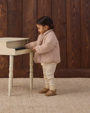 Load image into Gallery viewer, Side view of a toddler playing a toy piano, wearing the jacket’s smooth pink side outward with a shearling collar.