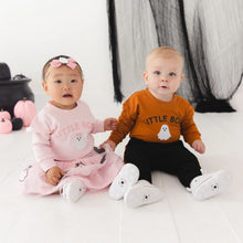 Load image into Gallery viewer, Two babies sitting on a white floor wearing matching 'Little Boy' themed outfits, with one in a pink dress and the other in an orange long-sleeve shirt with black pants, in a Halloween-themed room with pumpkins and a cauldron.