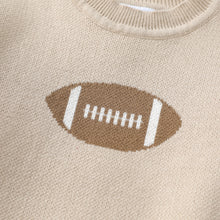 Load image into Gallery viewer, Close-up of a beige knit sweater with a brown and white football graphic on the chest.