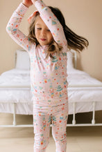 Load image into Gallery viewer, Child dancing with arms overhead in pale pink Sugar Plum pajamas with pastel nutcrackers, ballerinas, and holiday sweets.