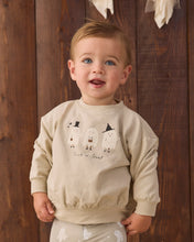 Load image into Gallery viewer, A toddler wearing a beige long-sleeve sweatshirt and matching pants with a 'Trick or Treat' ghost graphic, standing against a dark wood plank background.