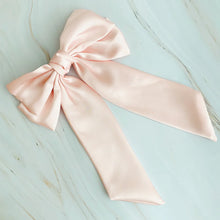 Load image into Gallery viewer, Large pink satin bow on a light blue wooden surface