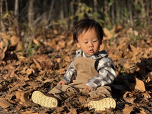Load image into Gallery viewer, Child sitting on dry leaves in a forest
